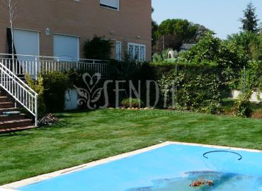 Diseño de jardín con césped natural, piscina y jardinería perimetral