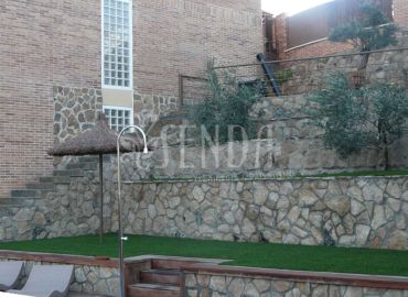 Jardín con piscina, terrazas de piedra y vegetación ornamental